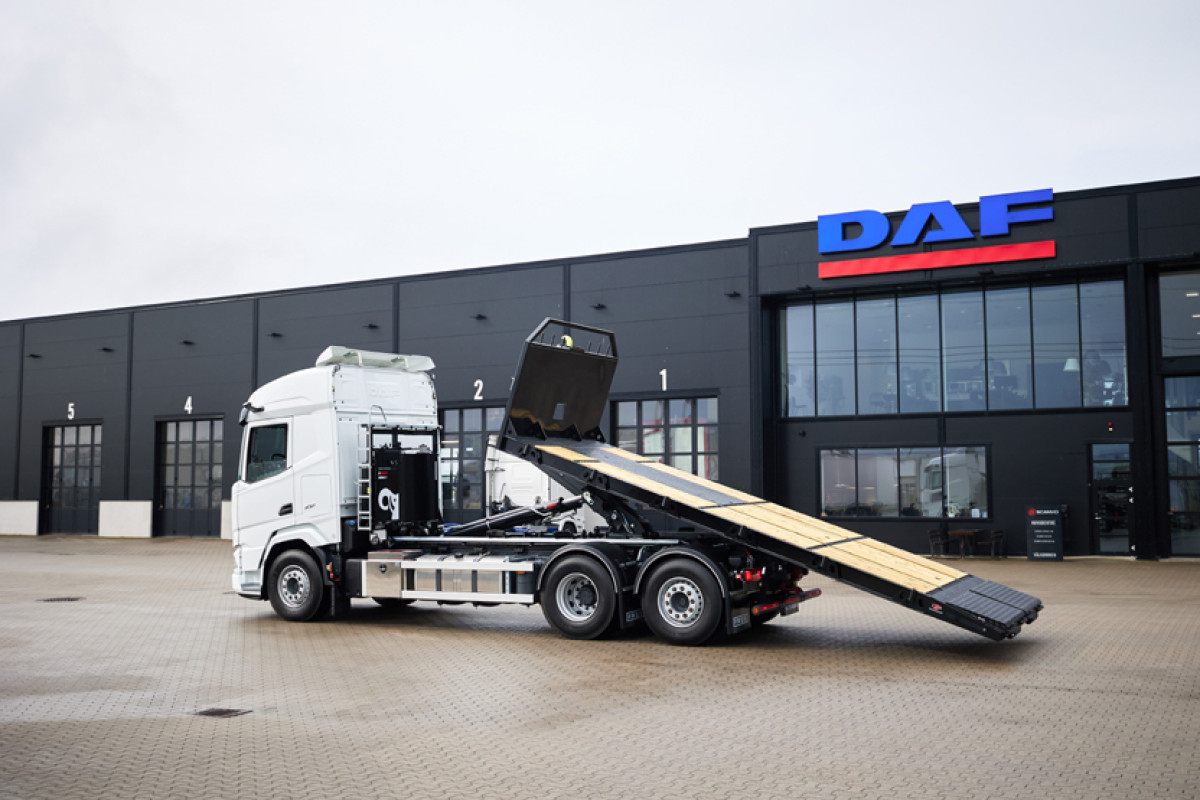 Flatbed with ladders on the flatbed and aluminum ramps.